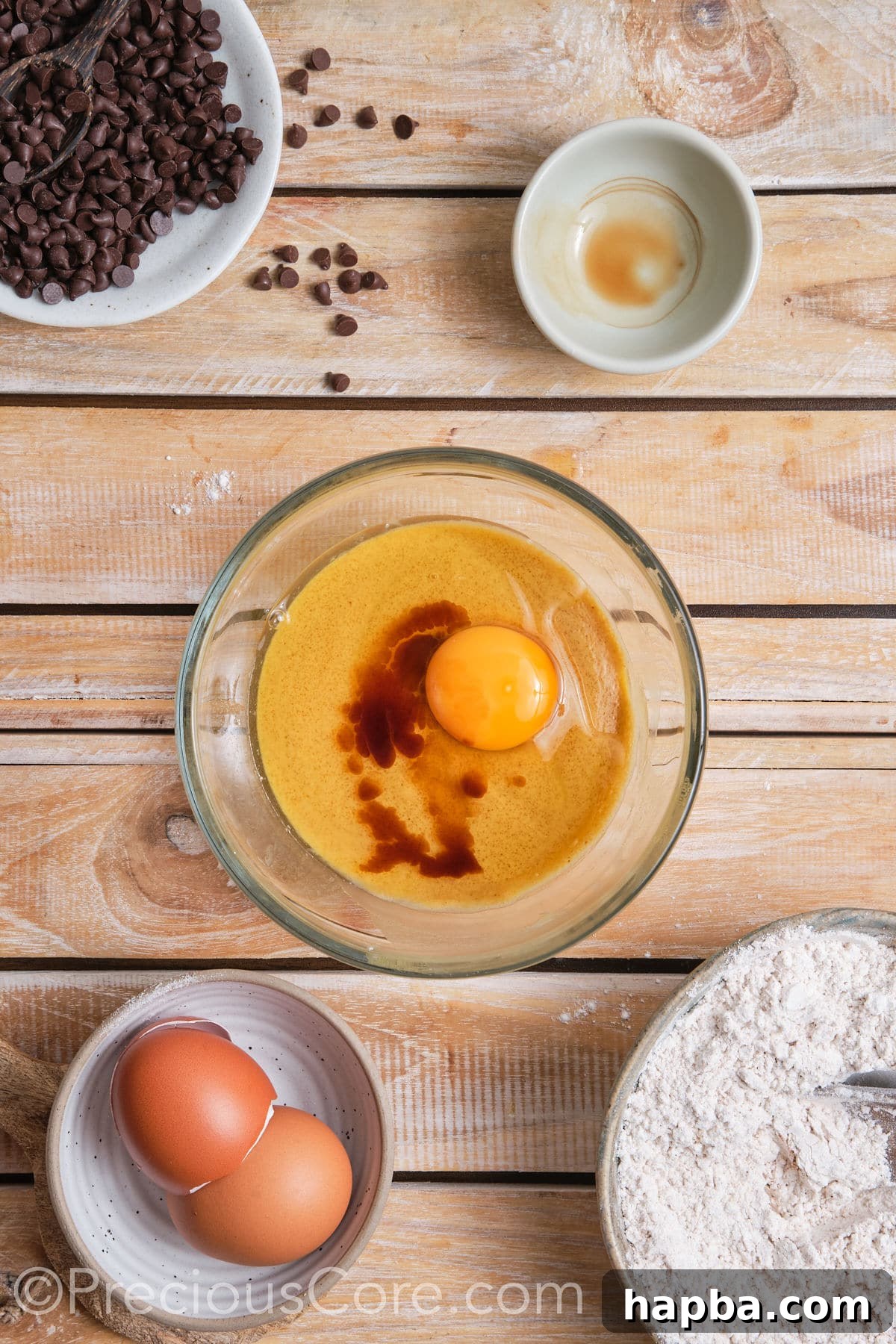 Adding a room temperature egg and vanilla extract to the creamed butter and sugar mixture.