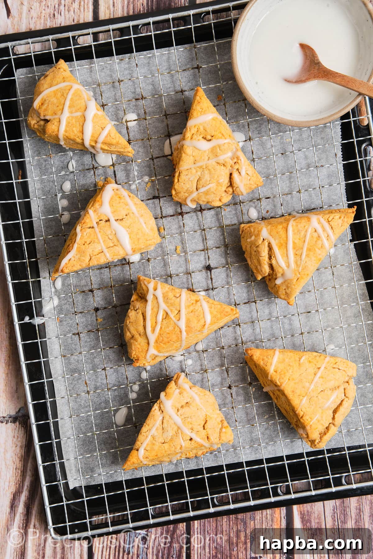 Golden Sweet Potato Scones 18 Sweet potato scones with a delicate white glaze drizzled artistically over their tops.