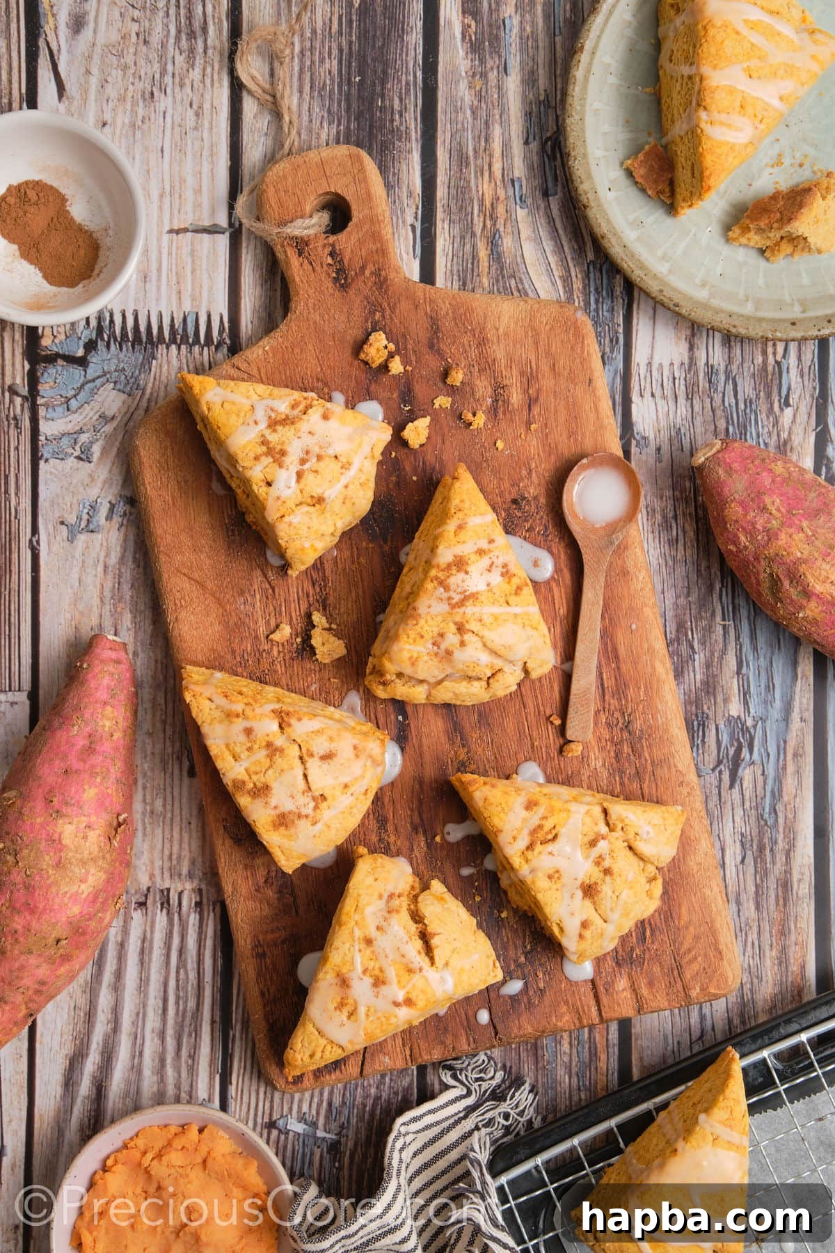 Golden Sweet Potato Scones 5 Freshly baked sweet potato scones cooling on a wooden chopping board, their tops glistening slightly.