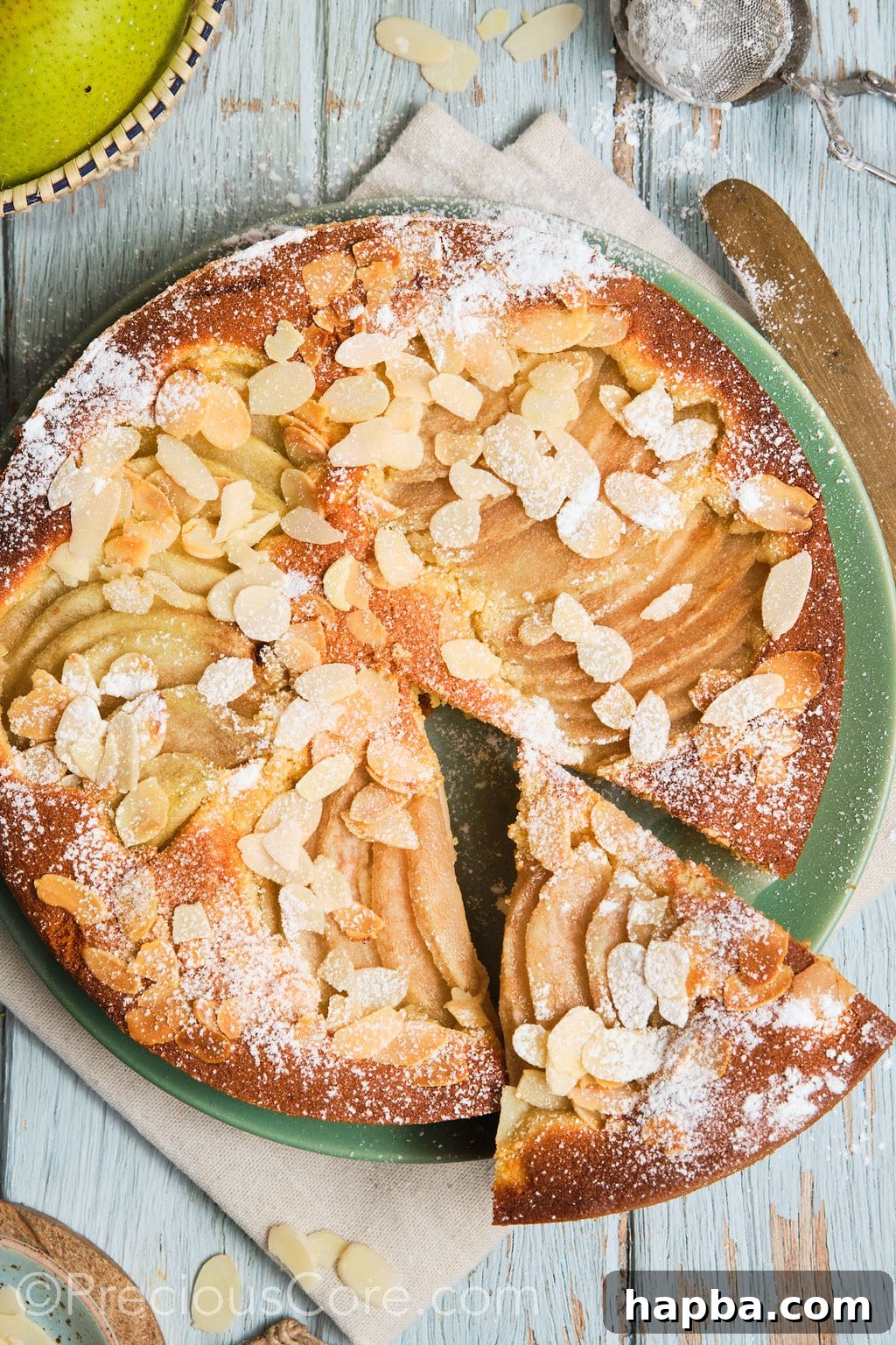 Italian pear almond cake on a plate with a slice cut out.