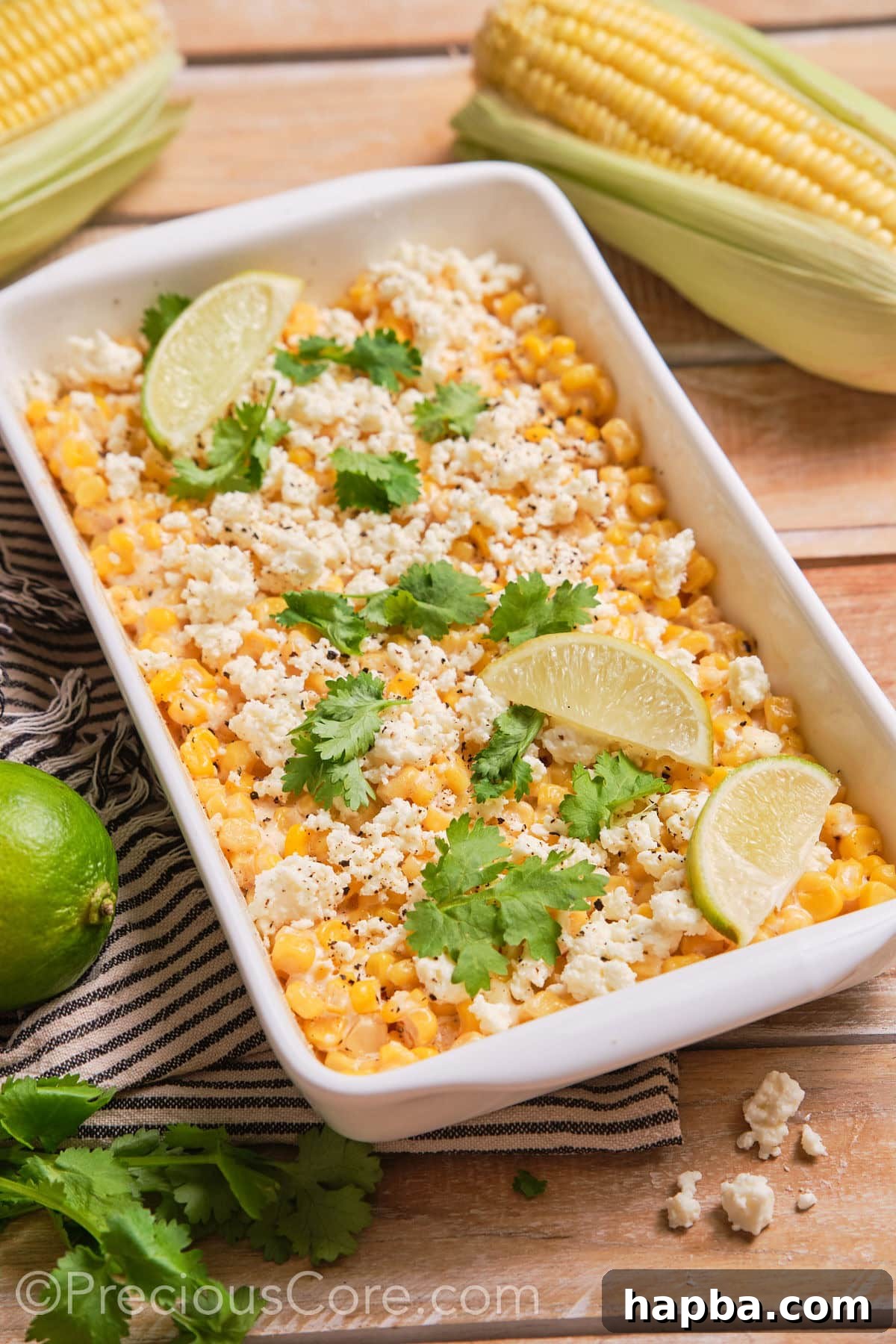 Creamy Elote Bake 2 Creamy Mexican Street Corn Casserole served in a white baking dish, garnished with fresh herbs.