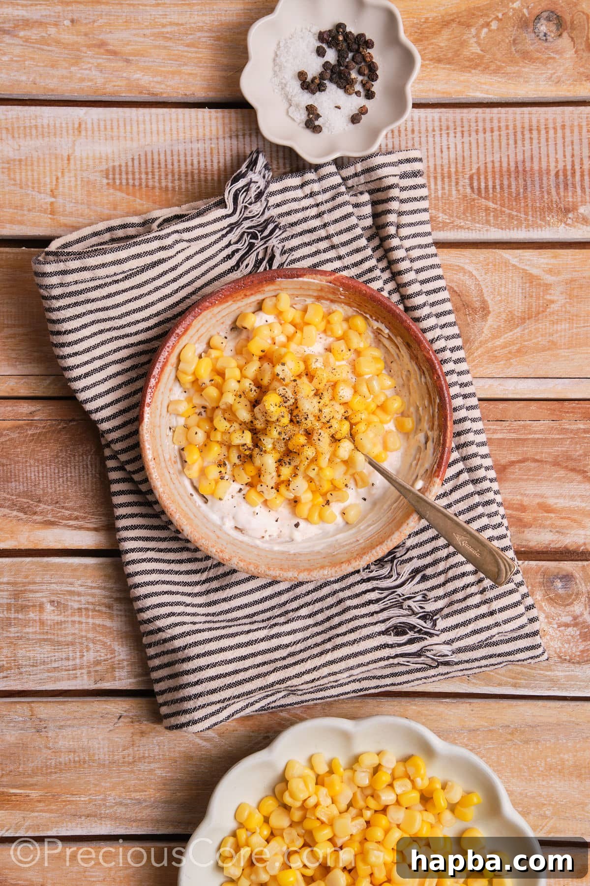 Creamy Elote Bake 5 Mixing thawed corn kernels with a rich, creamy sauce in a bowl, seasoned with salt and pepper.