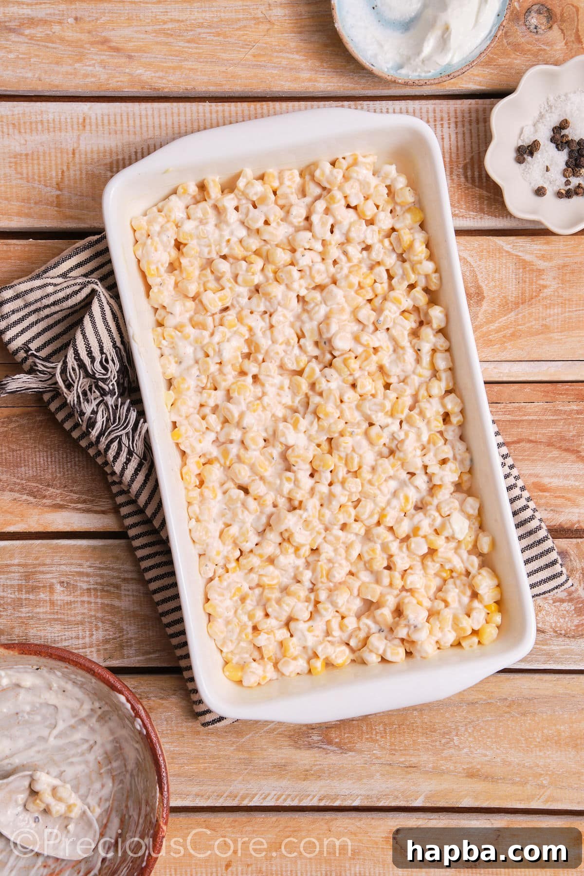 Creamy Elote Bake 6 Creamy corn casserole baking in a white oven-safe dish, heating through.
