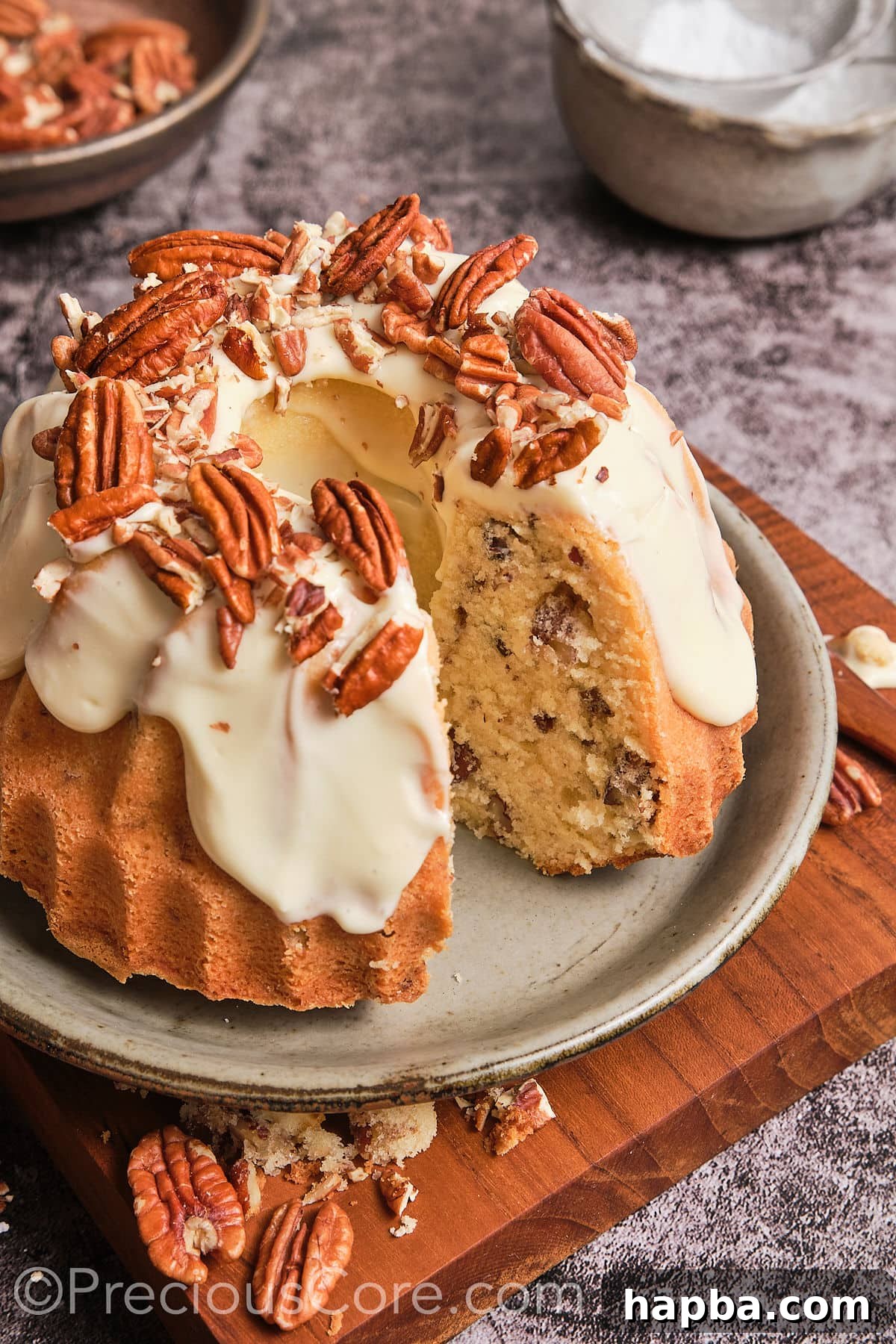 Decadent Butter Pecan Pound Cake 2 Butter pecan pound cake with a slice taken out, showcasing its moist texture and rich frosting.