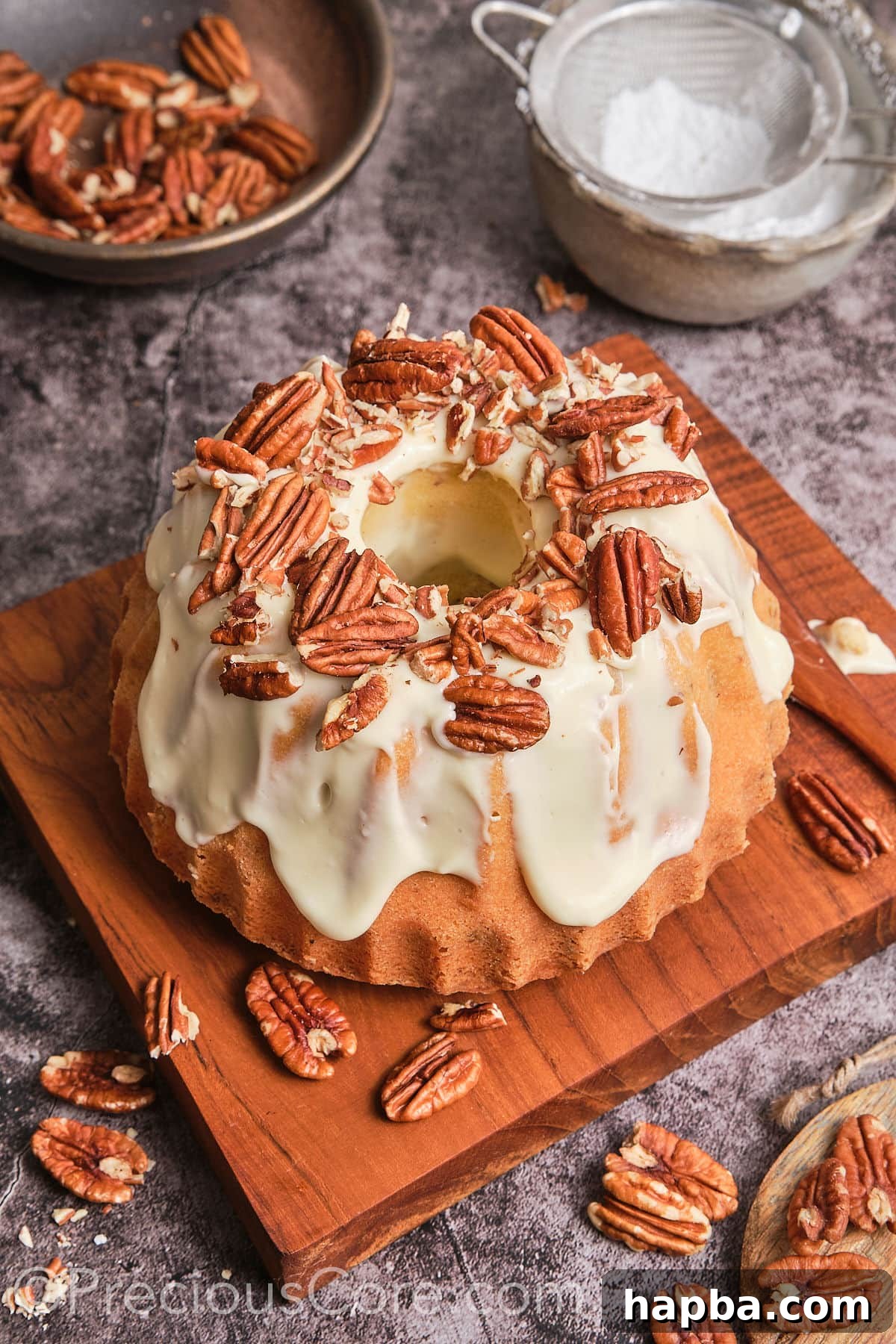 Decadent Butter Pecan Pound Cake 19 A whole, beautifully frosted Butter Pecan Pound Cake displayed on a rustic wooden plank.