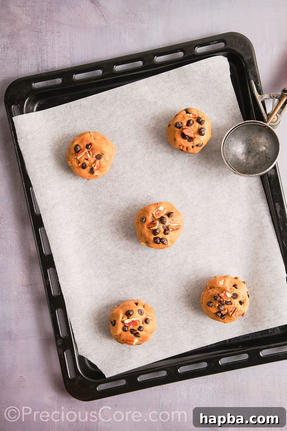 Cookie dough scooped onto a prepared baking sheet. 