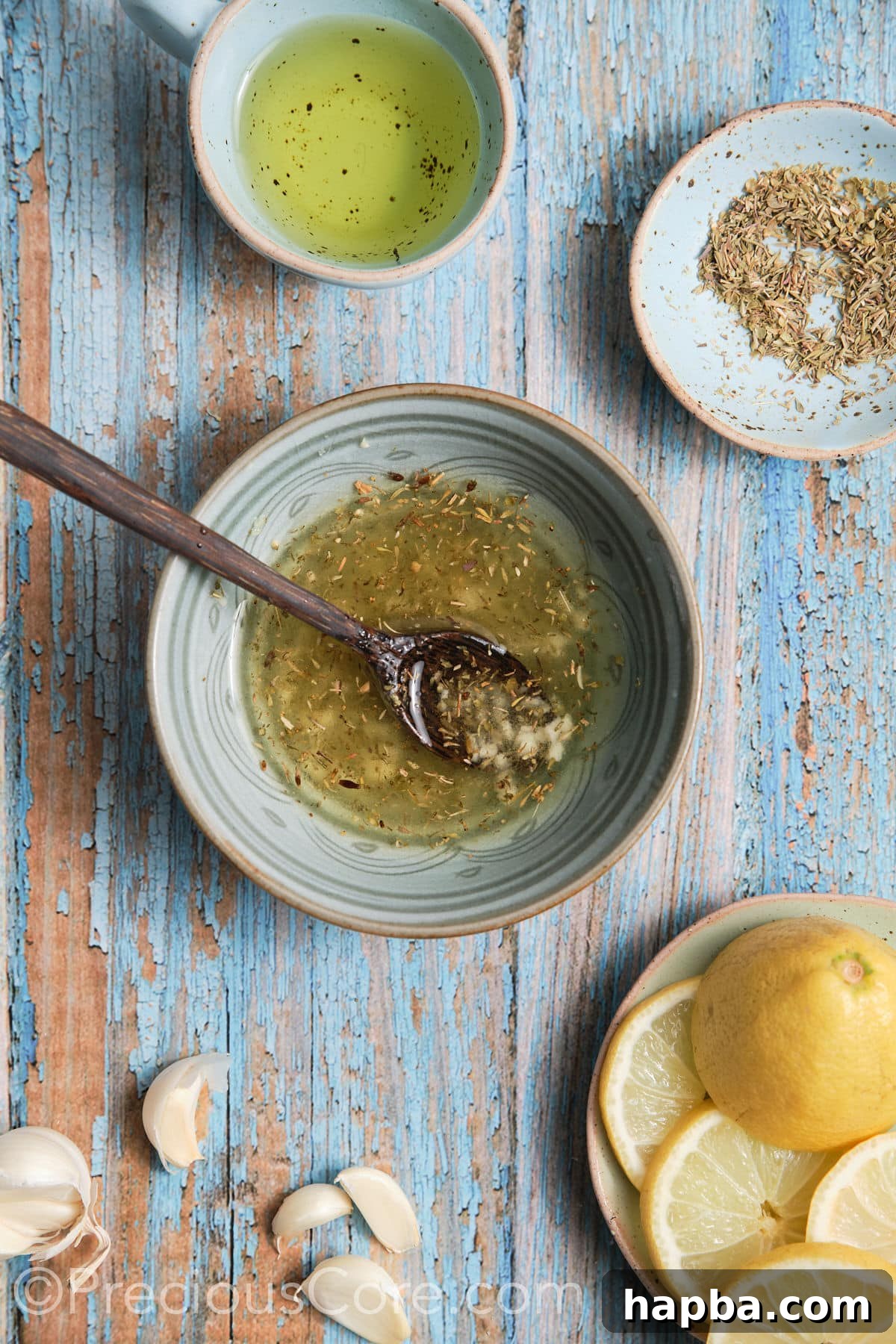 A small bowl containing the freshly prepared marinade for the baked Mediterranean fish, a blend of olive oil, lemon juice, minced garlic, oregano, and thyme.