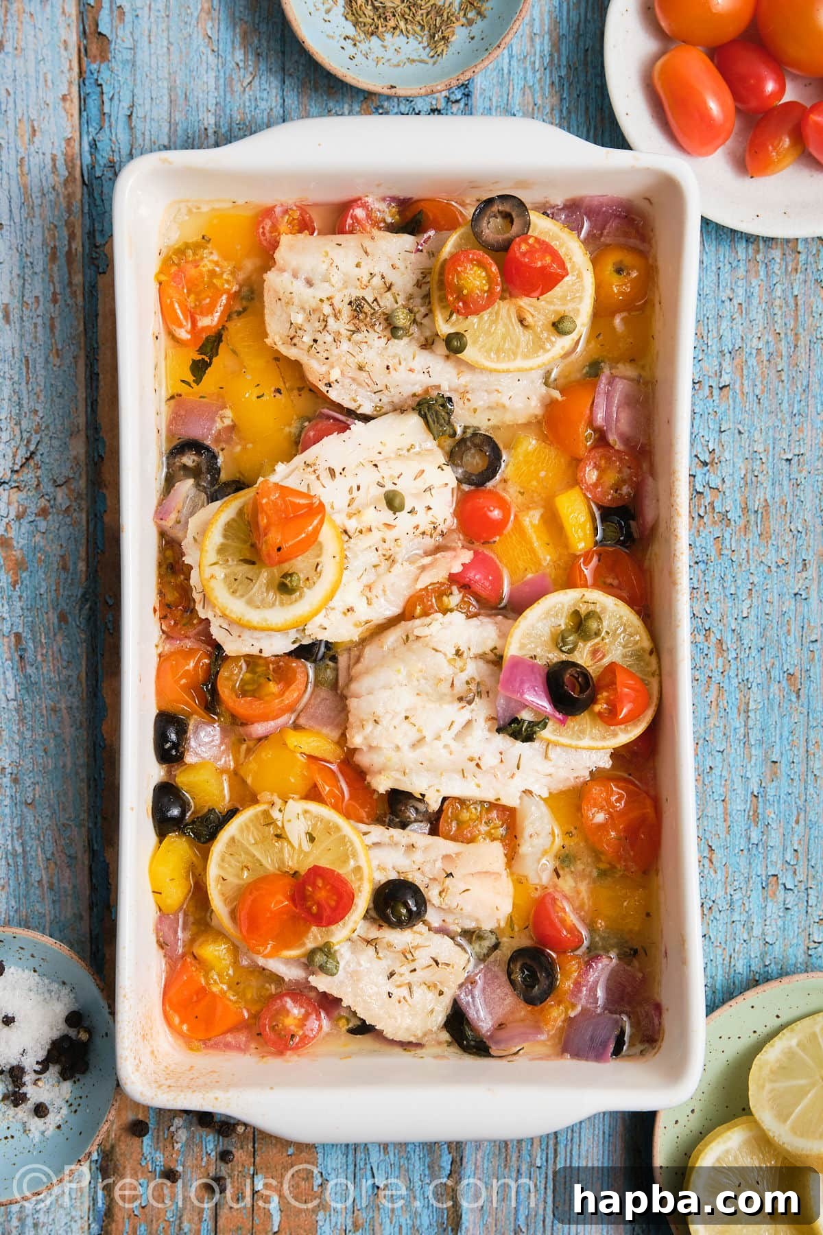 The finished baked Mediterranean fish and roasted vegetables, beautifully cooked and still in the pan, ready to be served.