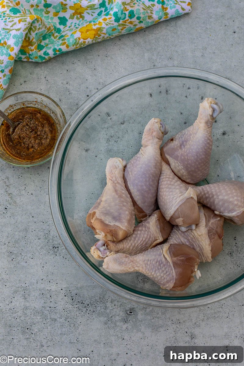 Golden Lemon Pepper Drumsticks 5 Chicken drumsticks that have been patted dry in a large mixing bowl, ready for marinade.