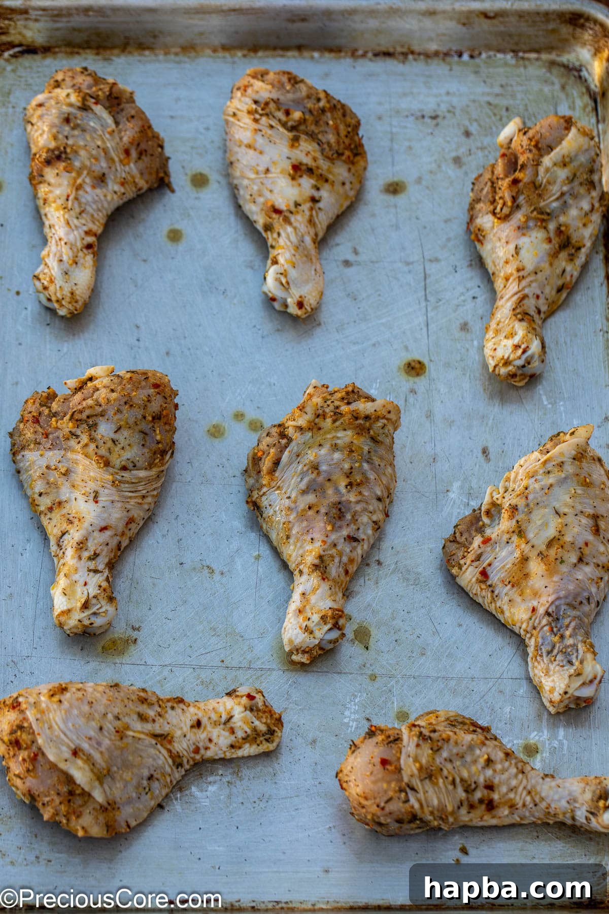Golden Lemon Pepper Drumsticks 8 Marinated chicken drumsticks arranged neatly on a baking sheet, ready for the oven.
