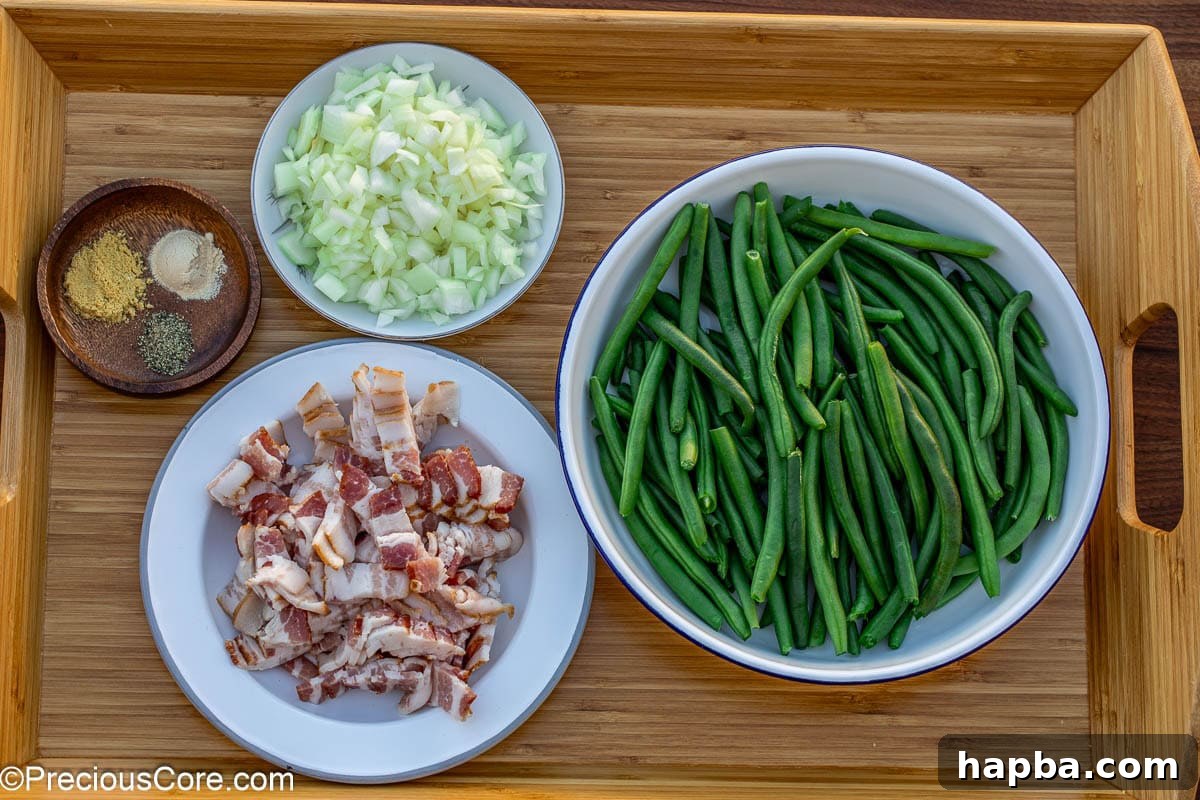 All the ingredients neatly laid out on a kitchen counter for making green beans with bacon.