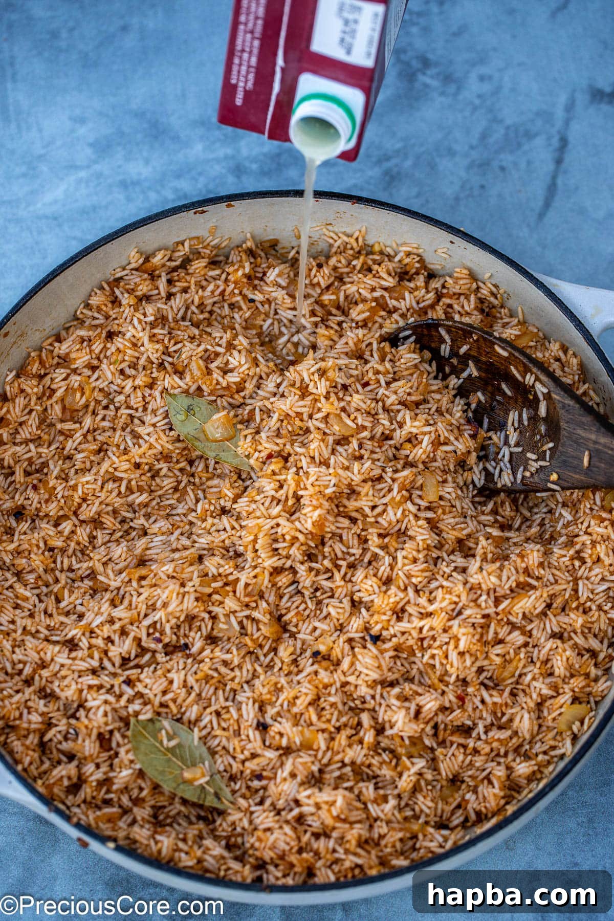 adding chicken broth to the rice.