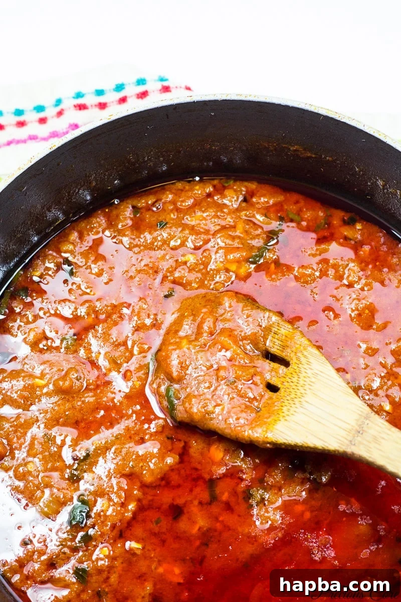 African Spiced Meatballs 11 Rich, simmering tomato sauce in a pan, ready for the meatballs.