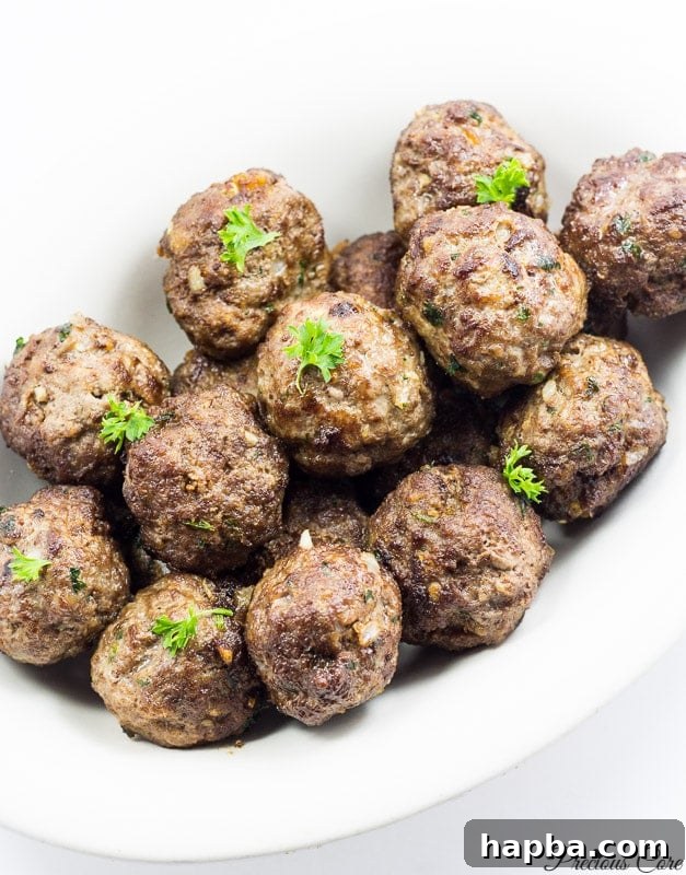 African Spiced Meatballs 9 A white dish filled with beautifully cooked and browned meatballs.