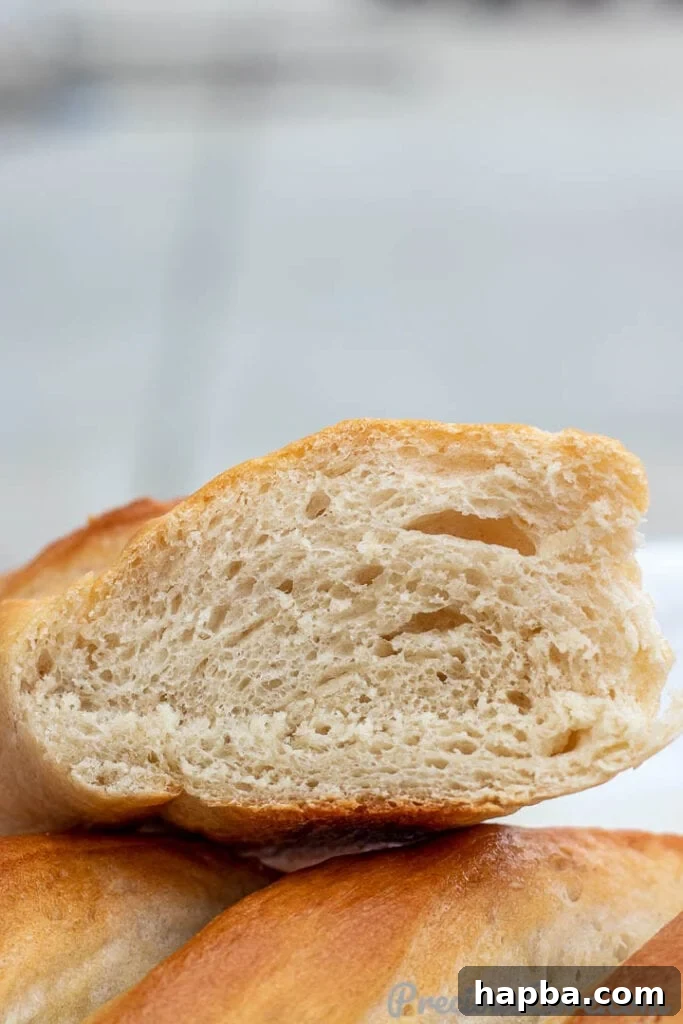 A sliced loaf of French Bread revealing its airy, open texture, ready to be enjoyed