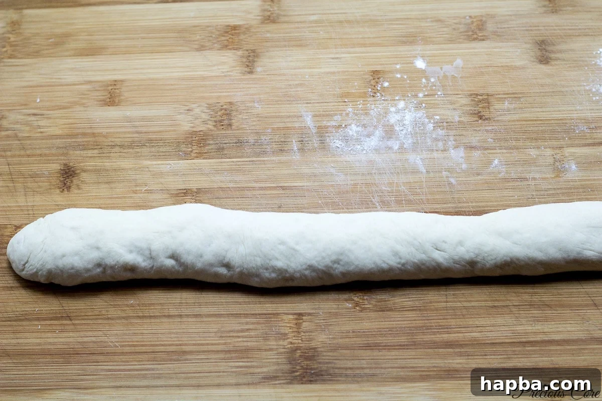 Close-up of a perfectly shaped French bread loaf, ready for the next step