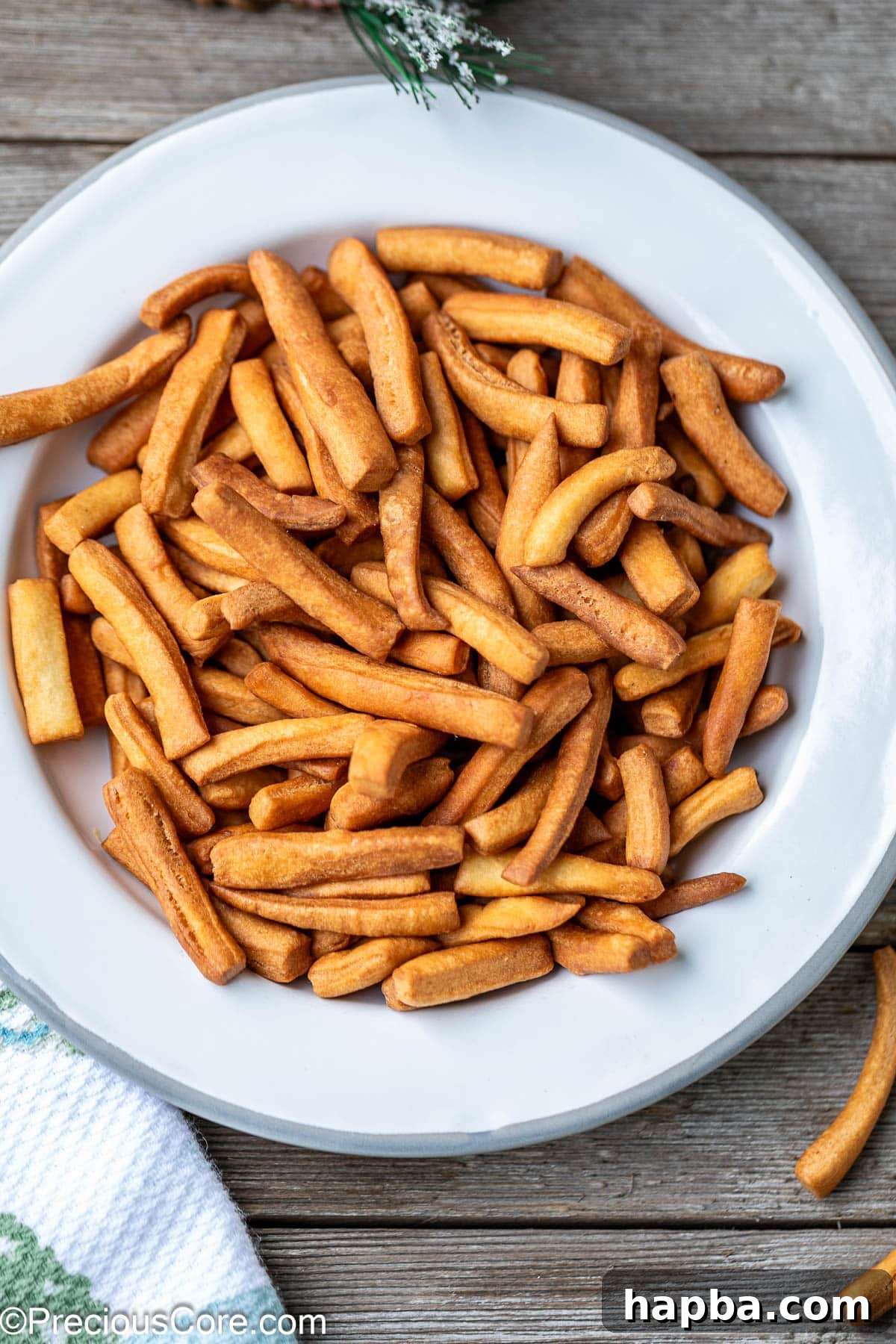 A close-up shot of perfectly golden-brown Chin Chin pieces arranged on a plate.