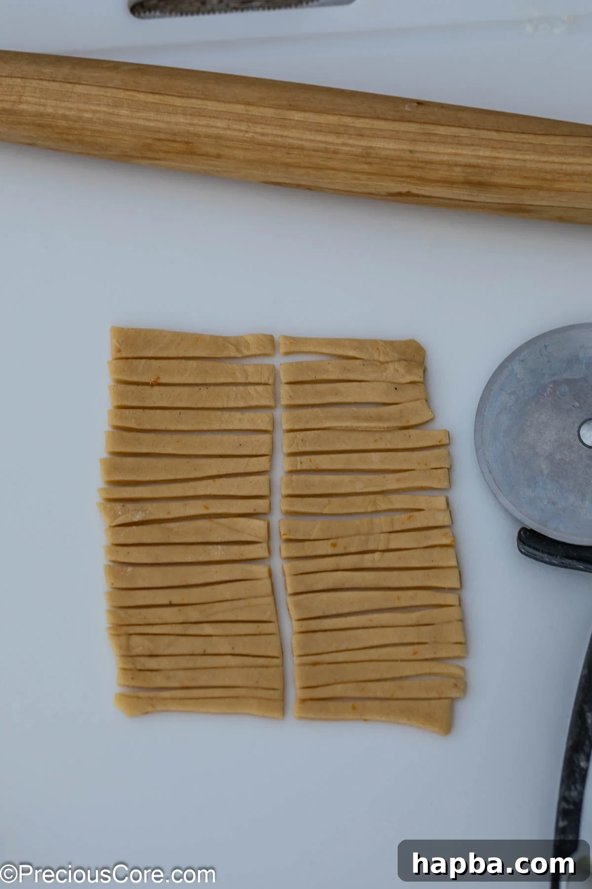 Chin Chin dough rolled out and cut into uniform strips using a pizza cutter.