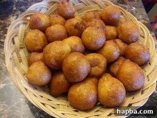 A street vendor serving fresh Puff-Puff and beans to customers, highlighting its popularity as street food.