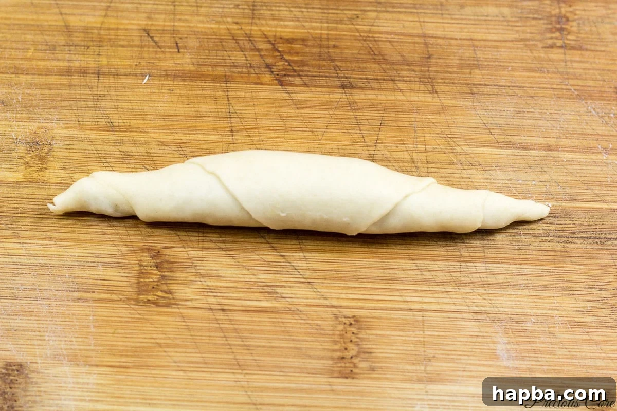Savory Cameroonian Fish Rolls 11 Rolling the filled dough to create the classic shape of Cameroonian fish rolls.