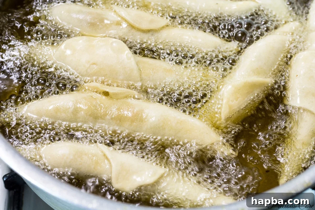 Savory Cameroonian Fish Rolls 13 Cameroonian fish rolls sizzling and turning golden brown in hot oil.