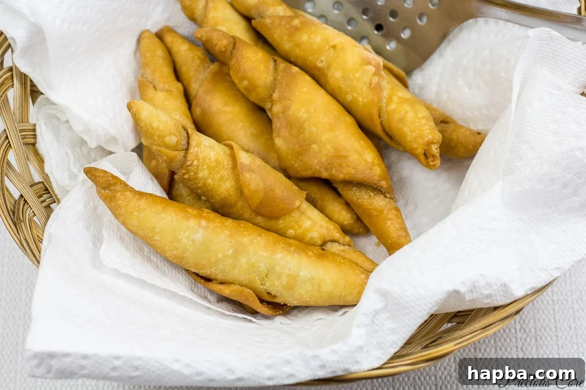 Savory Cameroonian Fish Rolls 15 Freshly fried Cameroonian fish rolls draining on paper towels.