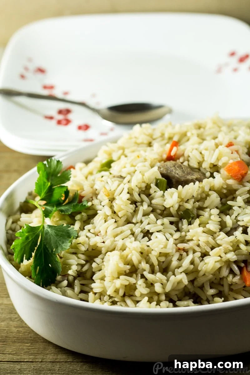 A large serving bowl filled with steaming Cameroonian Coconut Rice, garnished with fresh herbs and vegetables.