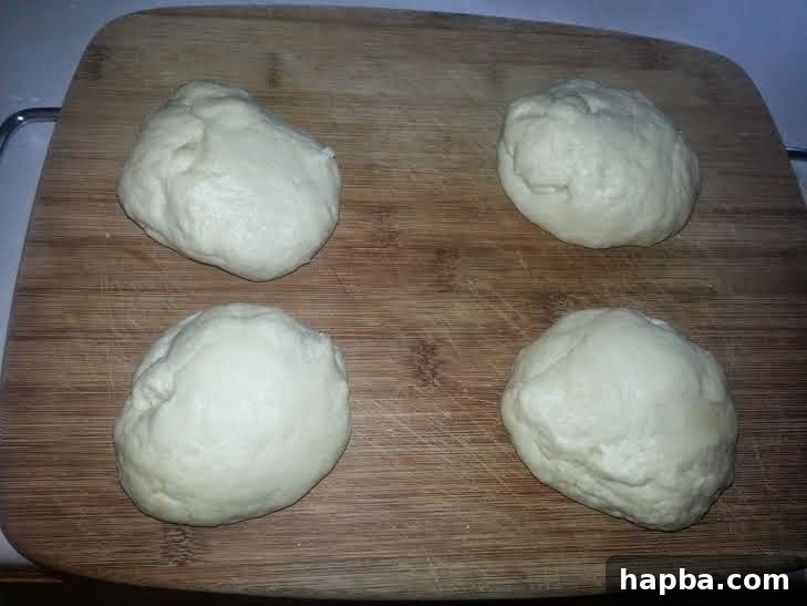 Simple Homemade Milk Bread 4 Dough divided into four equal portions on a board, ready for shaping