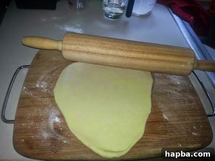 Simple Homemade Milk Bread 5 Dough piece rolled into an elongated oval shape, ready to be rolled