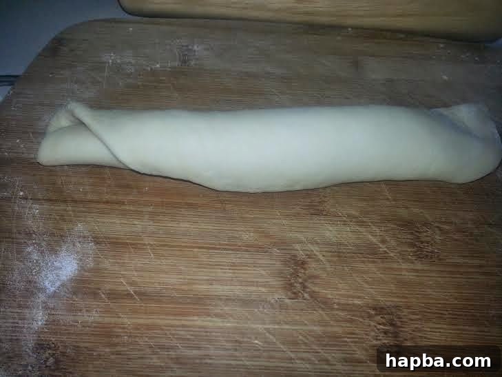 Simple Homemade Milk Bread 6 Dough being rolled tightly from one end to the other by hand