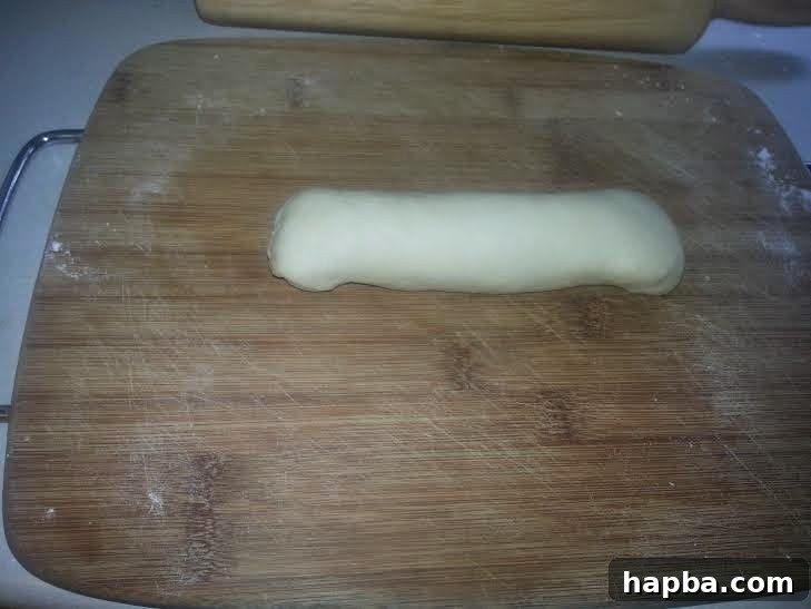 Simple Homemade Milk Bread 7 Rolled dough with edges folded in and the bottom seam pinched closed