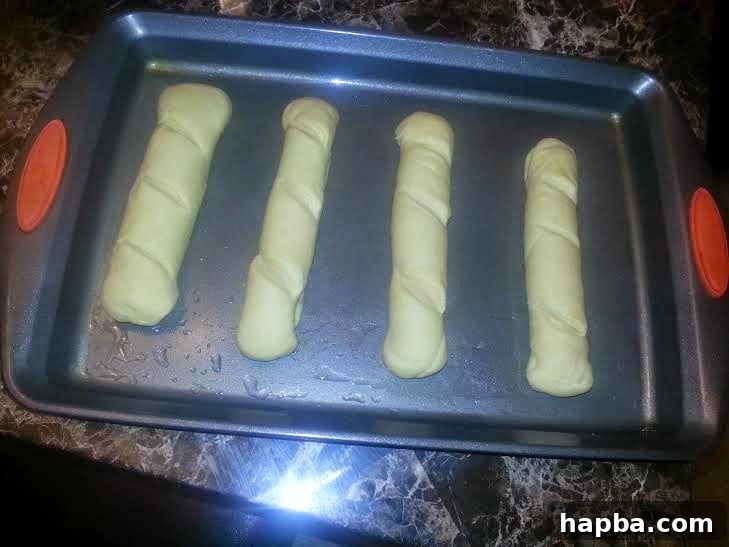 Simple Homemade Milk Bread 9 Four shaped milk bread loaves arranged on a greased baking tray for proofing