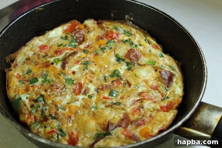 The baked frittata, golden brown and puffed, in the skillet.