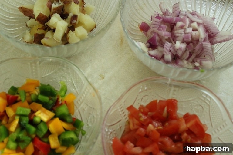 Chopped ingredients: potatoes, onions, tomatoes, and bell peppers.