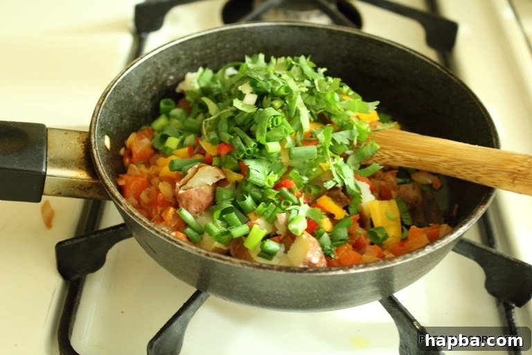 All chopped vegetables and potatoes mixed in the skillet.