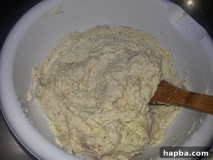 Mixing cocoyam paste with crayfish, smoked fish, and seasonings for flavor