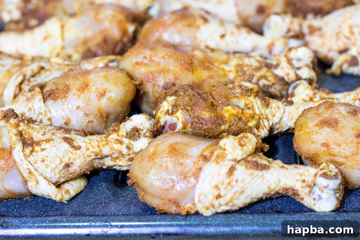 Chicken drumsticks generously coated in a flavorful African-style dry marinade, ready for grilling.