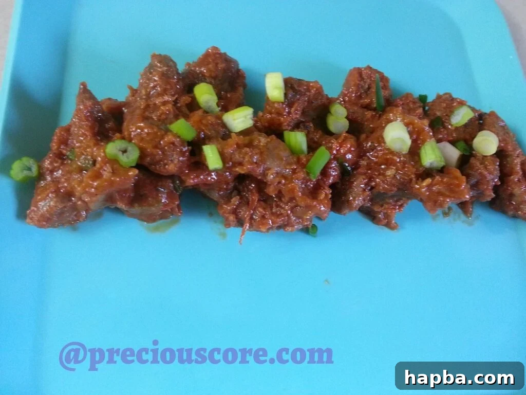 A savory dish of Peppered Chicken Gizzards, stewed in a rich sauce of tomatoes and peppers, ready to be served.