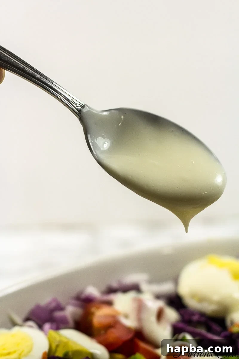 A close-up shot of the rich, creamy Cameroonian salad cream, showcasing its smooth texture, ready to be drizzled over fresh vegetables.