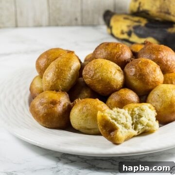 Plantain puff puffs on a white plate, showcasing their delicious golden exterior.