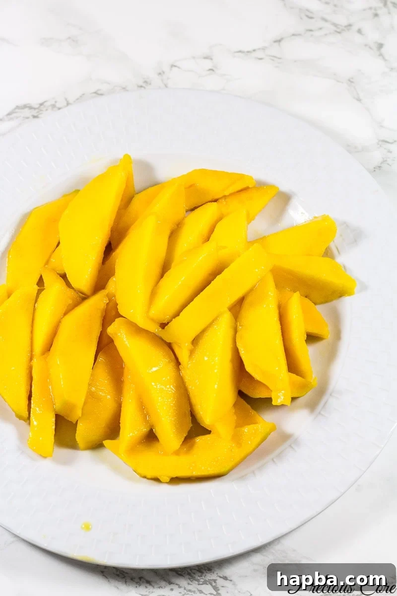 Tropical Mango Delight Cake 3 Beautifully sliced mango pieces presented on a clean white plate