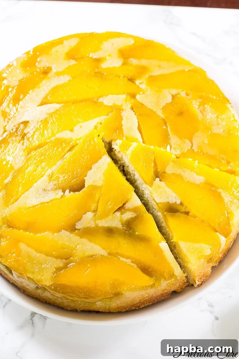Tropical Mango Delight Cake 8 A freshly flipped mango upside down cake, beautifully presented on a serving plate, ready to be enjoyed