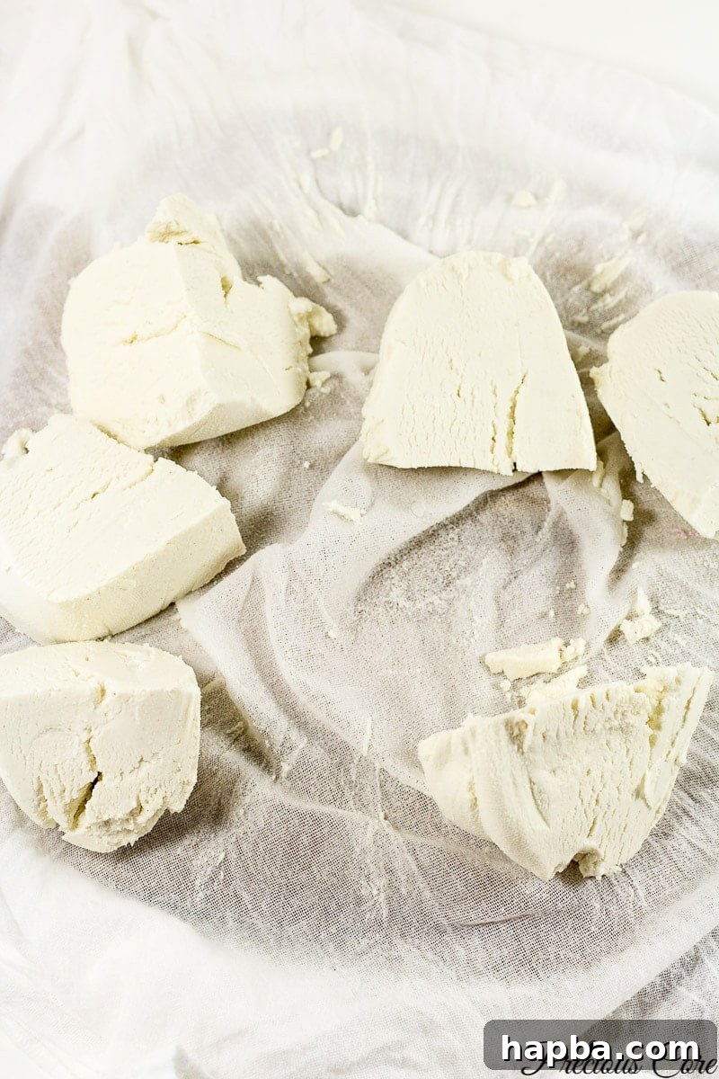 Raw pap paste, tightly wrapped and squeezed in a clean kitchen cloth, a method used for removing excess water and preparing it for storage.