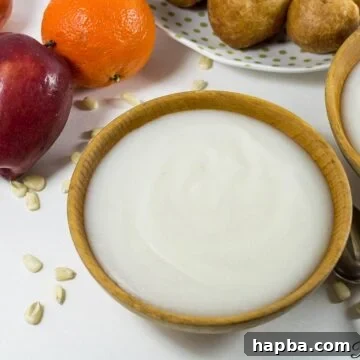 A wooden bowl filled with creamy, white pap, a staple fermented corn porridge, ready to be served.