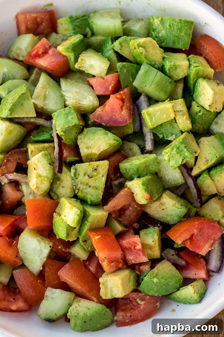 Bowl of avocado salad with tomatoes, onions, cucumber