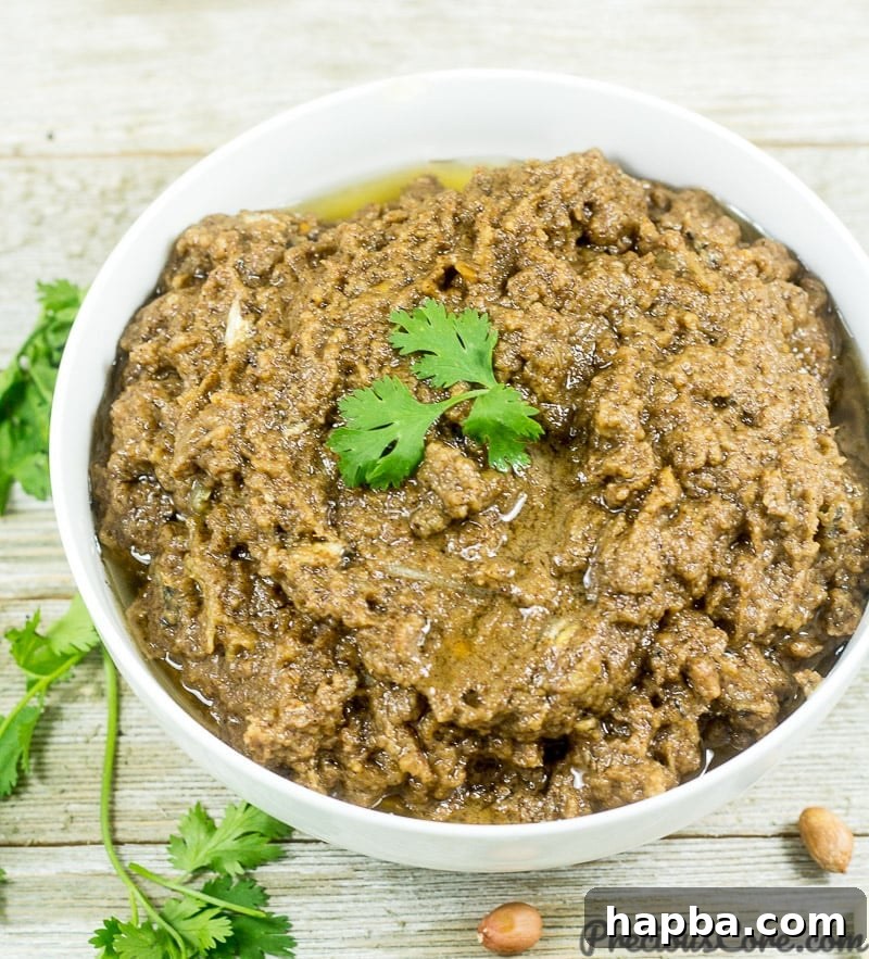 A beautifully presented bowl of Cameroonian Mboh, a rich groundnut paste, garnished and ready to be served.