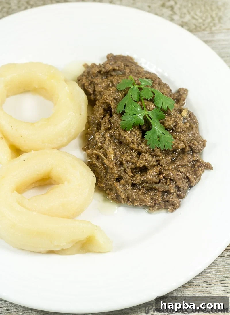 A serving of traditional Cameroonian Bobolo (cassava sticks) alongside a bowl of rich Mboh (groundnut paste), ready to be enjoyed.