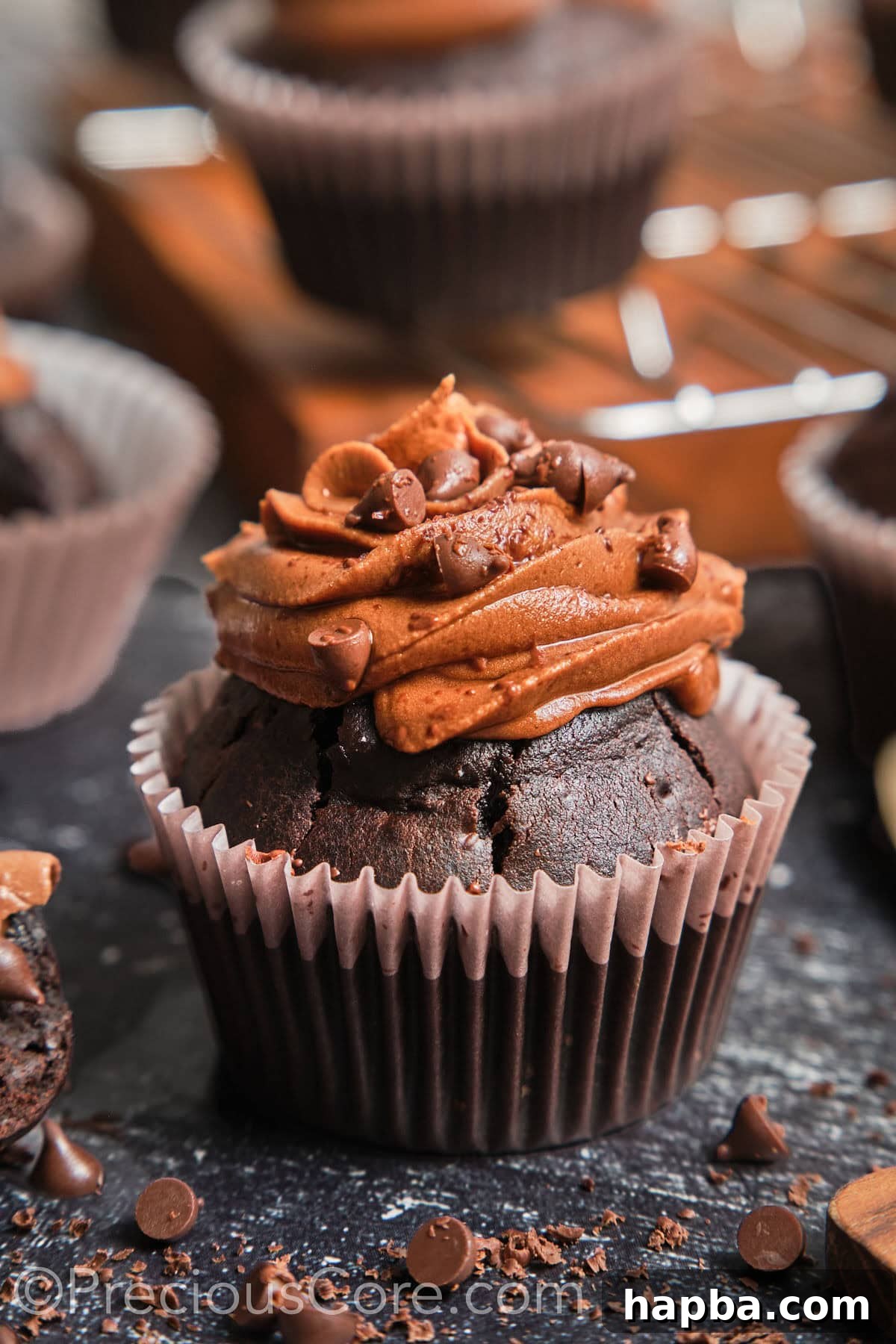 Zoom-in on a chocolate cupcake with chocolate frosting, showcasing its moist texture.