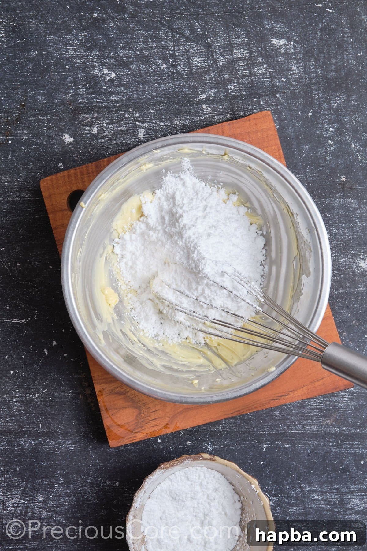 Whipping butter and powdered sugar together for the buttercream frosting base.