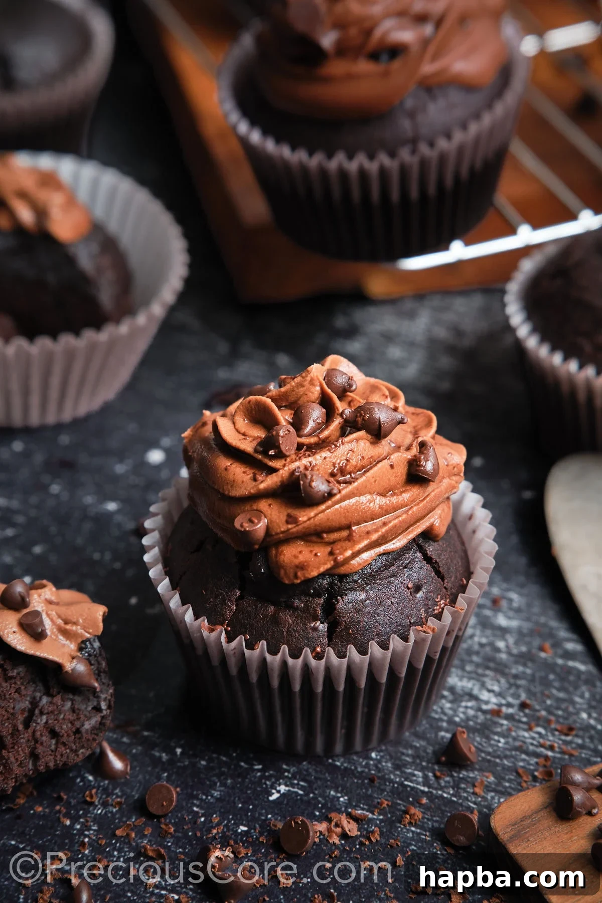 A beautifully frosted chocolate cupcake topped with extra chocolate chips, ready for serving.